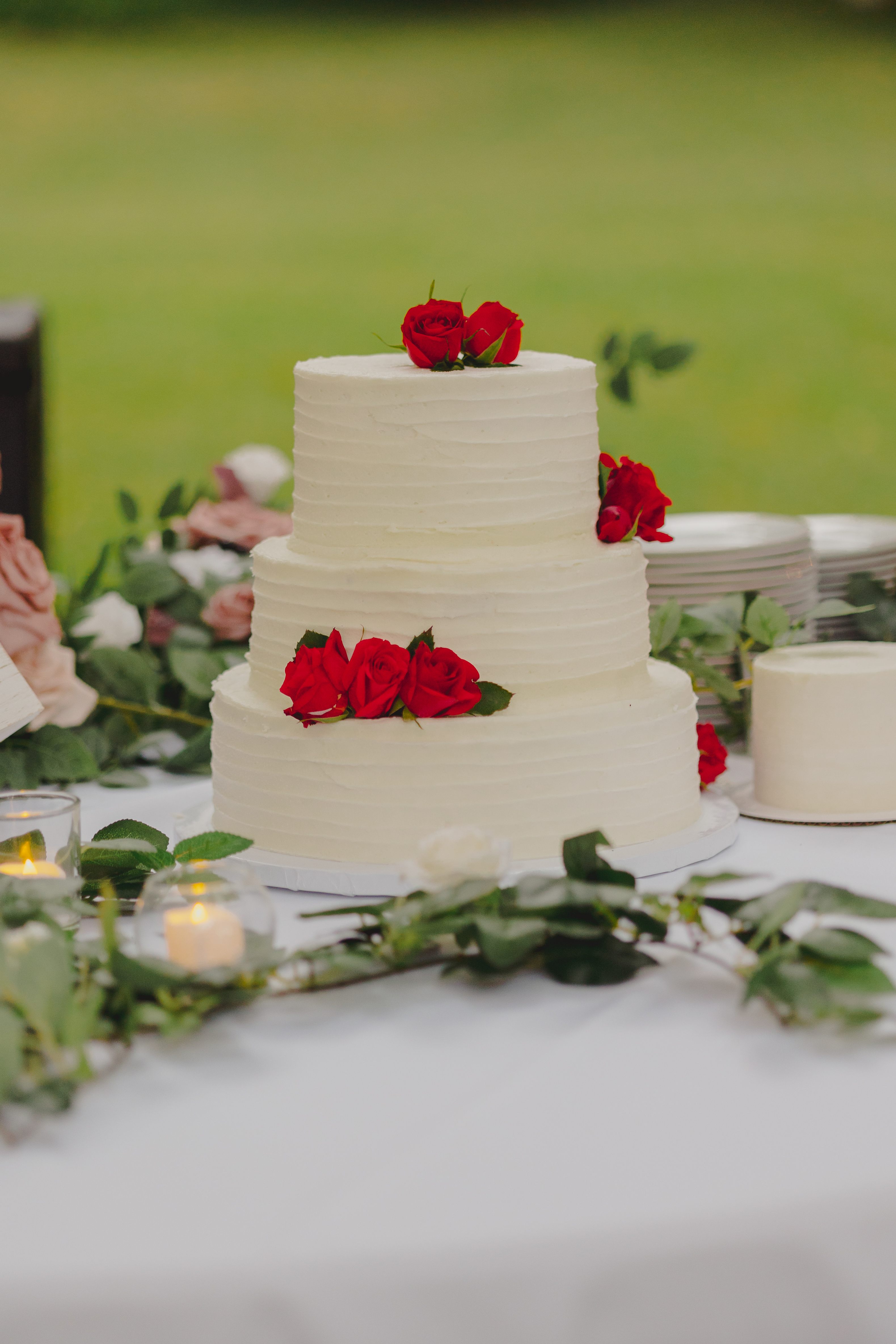 A photo of a white wedding cake with red flowers